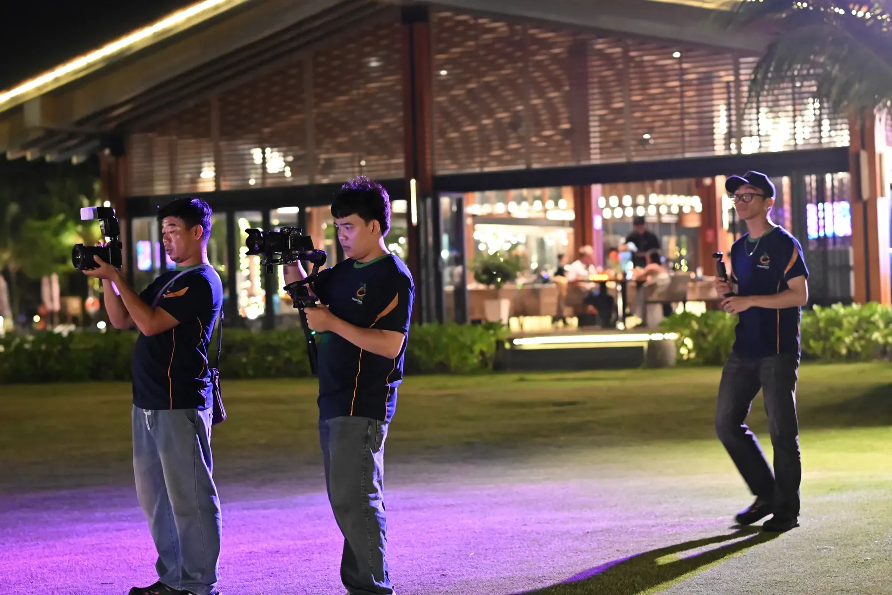 Phu Quoc Times Media photographers and filmmaker working together at an evening event.