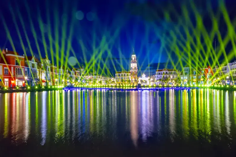 Green and blue show lights reflected in the Grand World canal at night