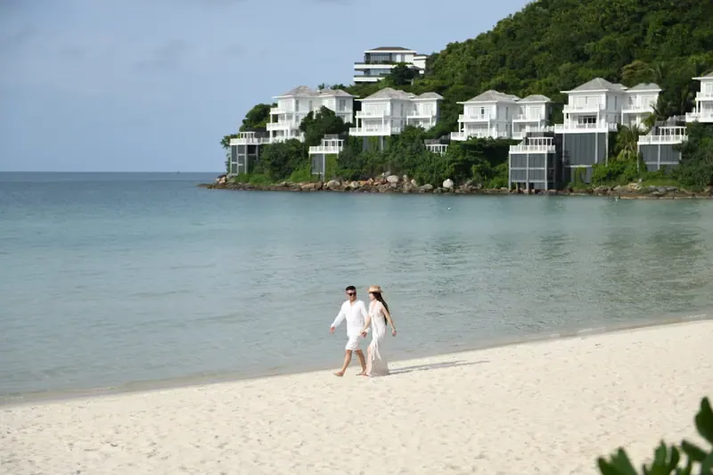 Couple walking on white sand at Khem Beach, Phu Quoc