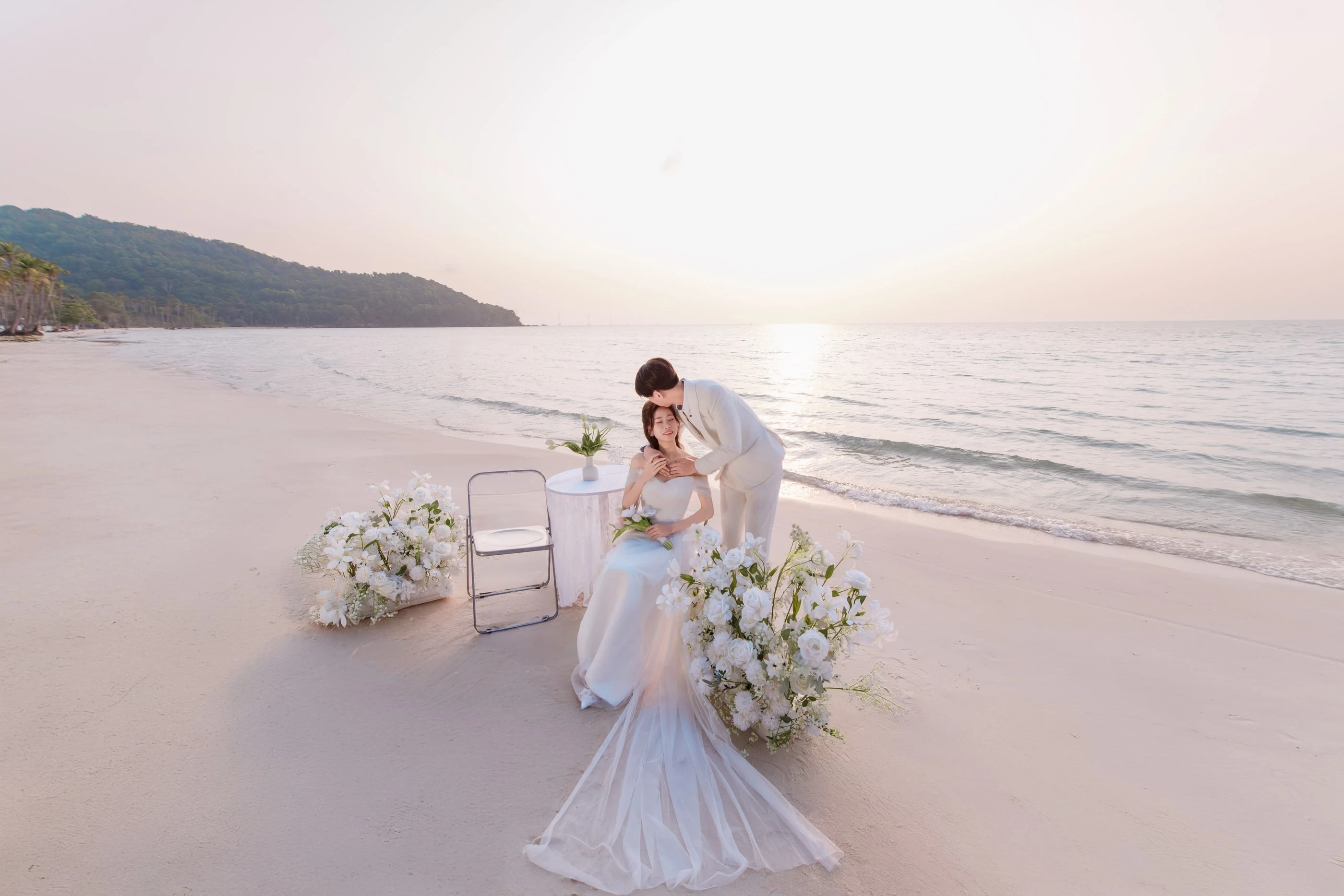 Cặp đôi trong trang phục cưới bên hoa trắng trên bãi biển Phú Quốc