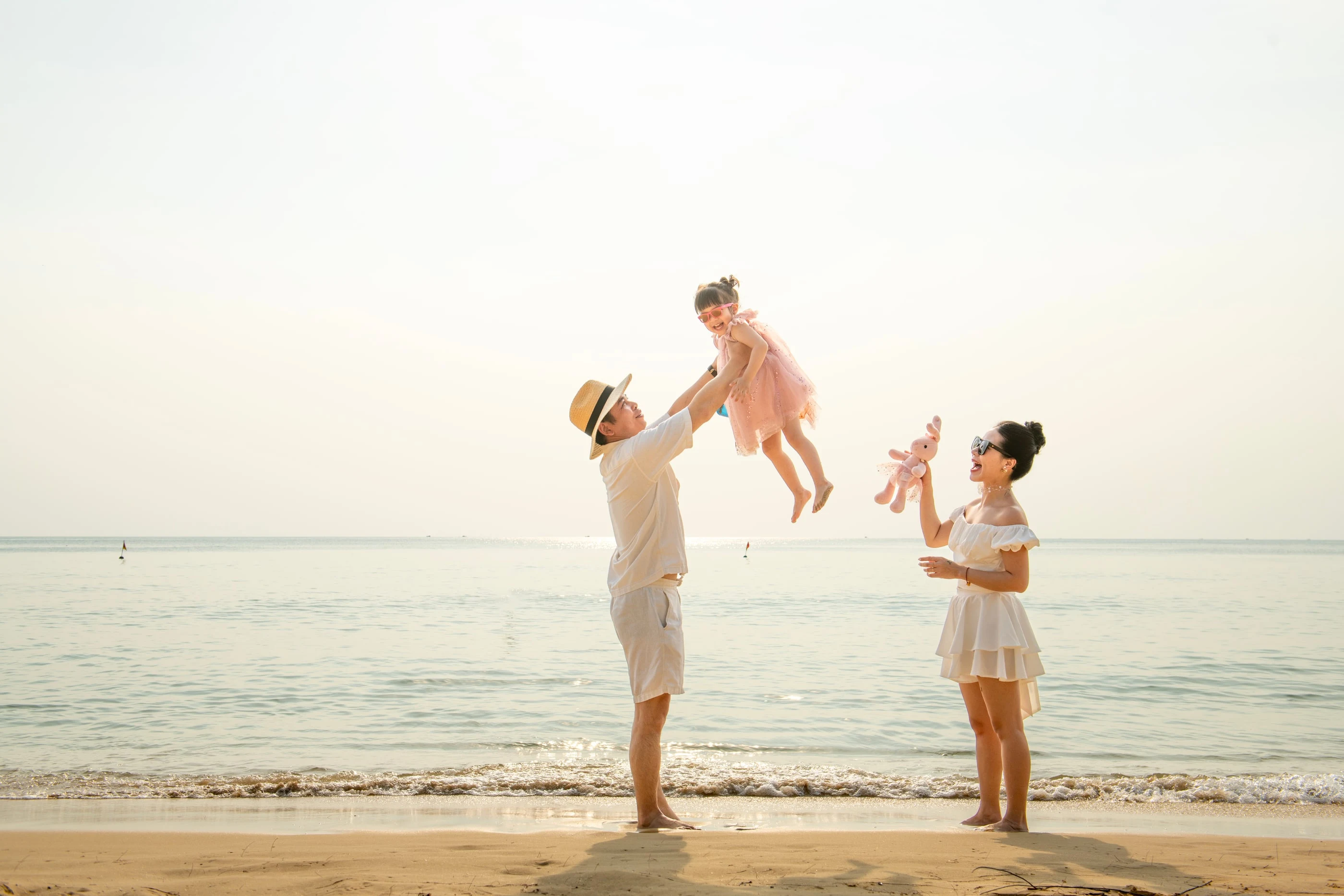 Cha mẹ vui đùa cùng con gái trong buổi chụp ảnh gia đình trên bãi biển Phú Quốc