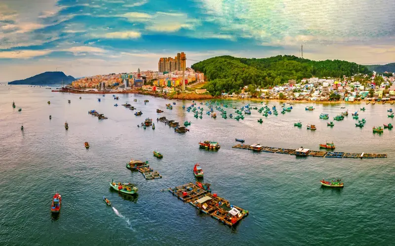 View towards Sunset Town across a bay filled with fishing boats and floating platforms